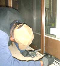 Worker installing screen on sliding door